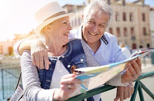 Ein älteres Paar schaut lächelnd in eine Stadtkarte.