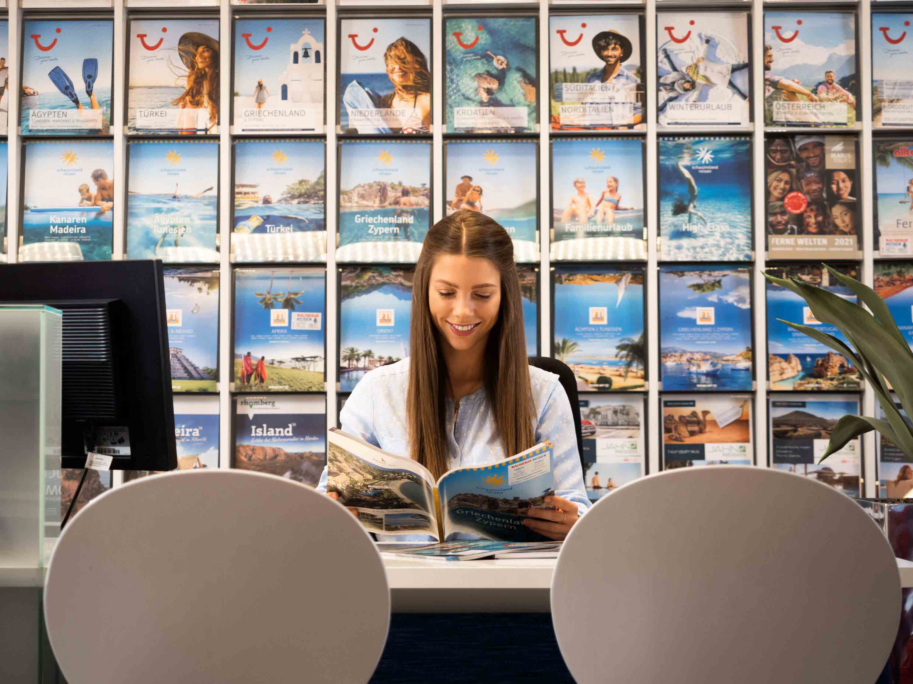 Eine Angestellte liest ein Katalog im Nachbaur Reisen Büro.