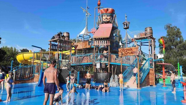 Kinder und Erwachsene spielen auf der Wasserattraktion mit dem Namen "Captain Splash!". 