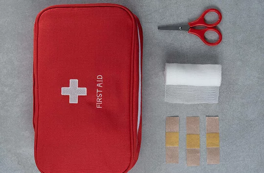Eine Reiseapotheke für die Städtereise, eine Schere ein Verband und ein Hautpflaster sind zu sehen.