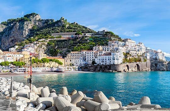 Eine Bucht in der Stadt Amalfi mit weißen Häusern auf einem Felsen gebaut.