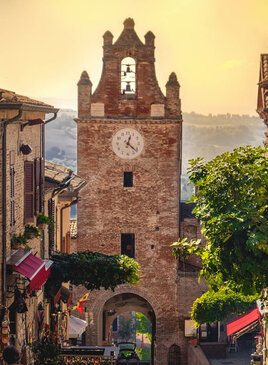 Ein Turm aus Ziegelsteinen mit einer Uhr vor abendlichem Himmel.