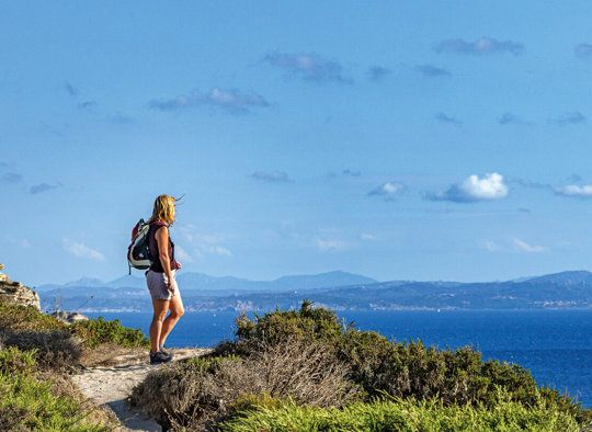 Frau beim wandern mit Blick aufs Meer